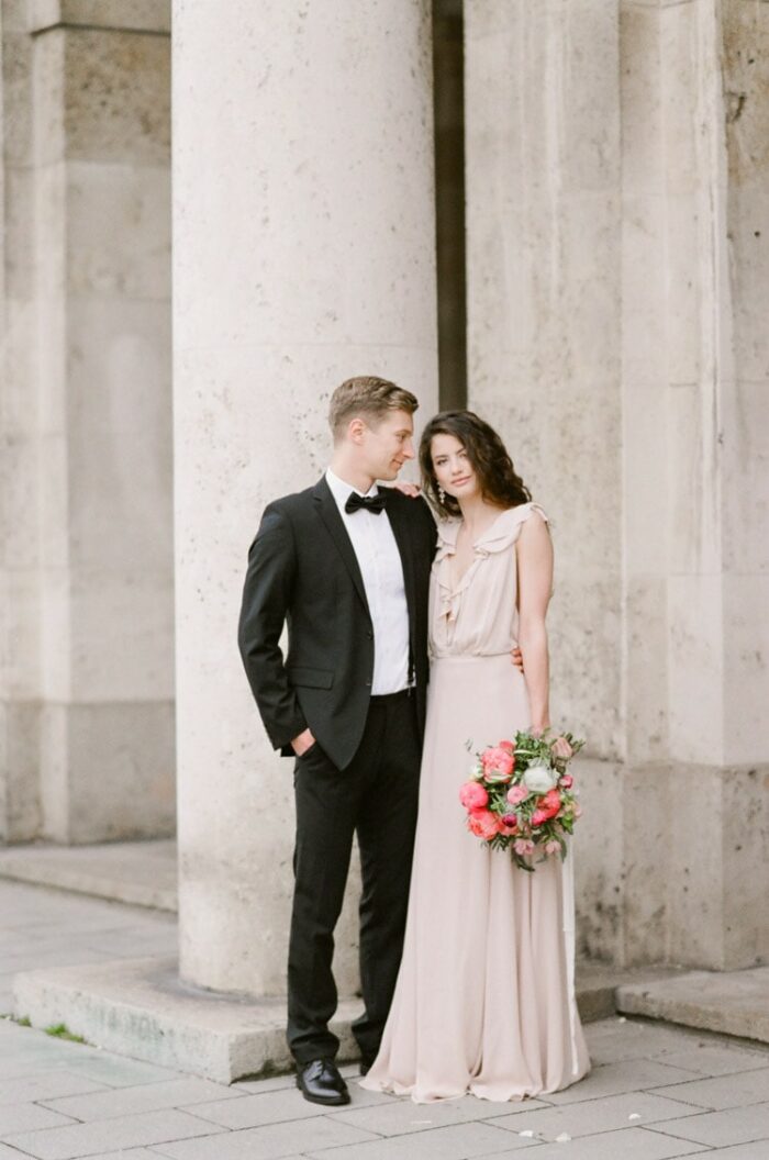 Engagement portraits in front of old columns in Munich