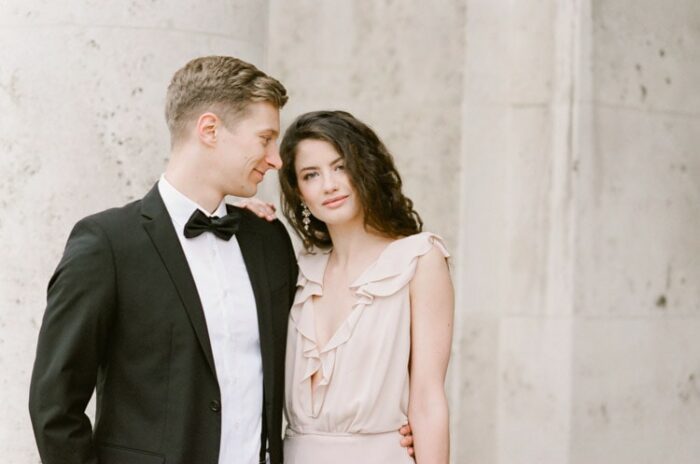 Engagement portraits in front of old columns in Munich