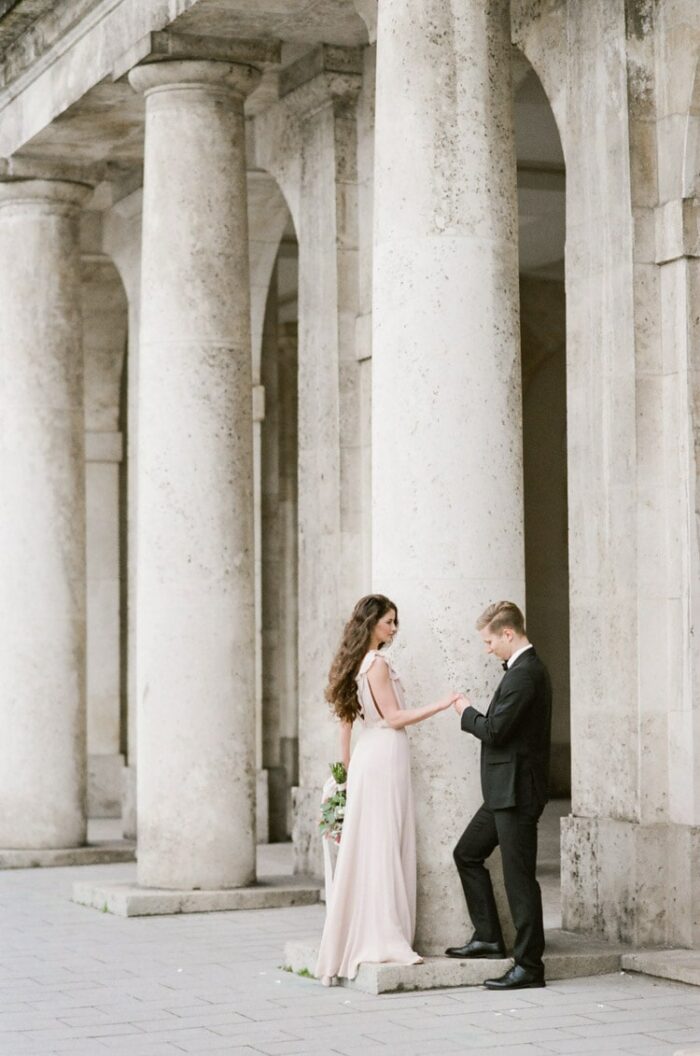 Couple standing in front of columns in Munich