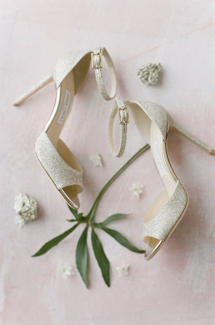 High heels with ankle straps against a pink background