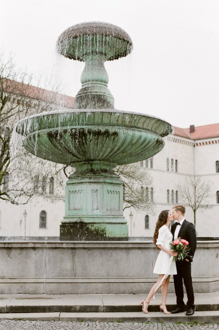 Couple kissing in front of Munich fountain