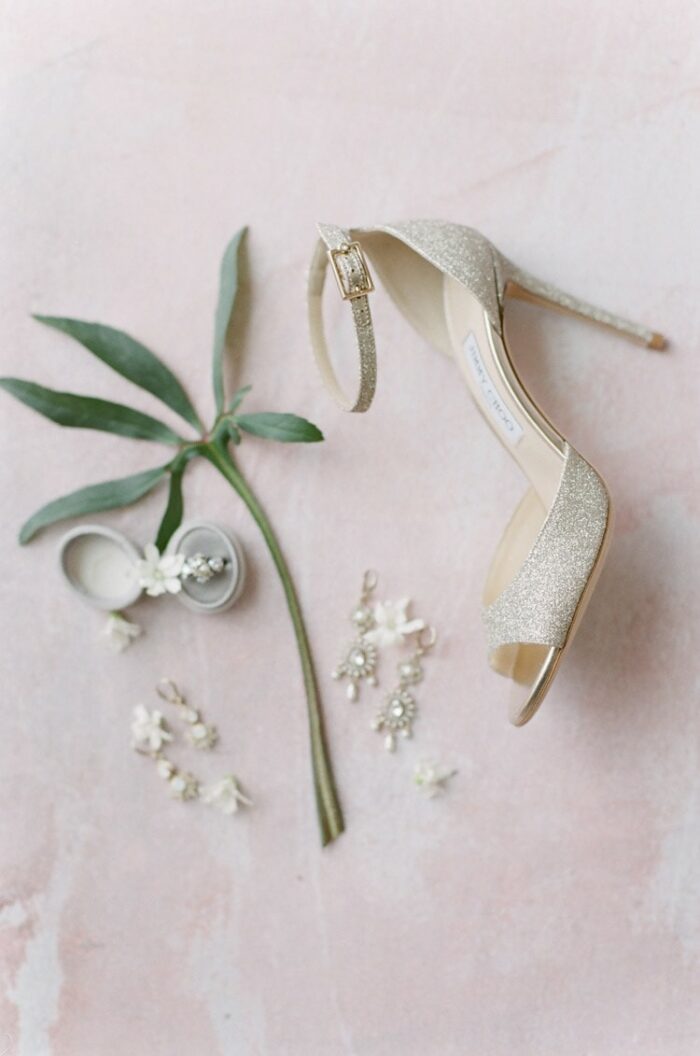 High heels with ankle straps against a pink background