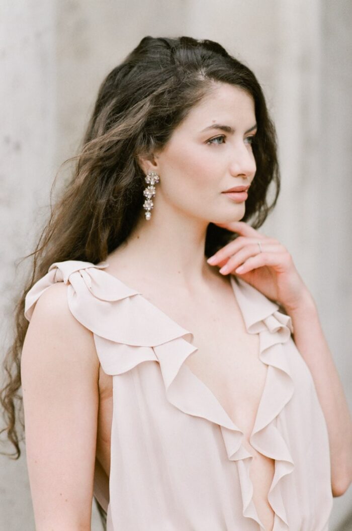 Woman wearing ruffled gown and drop earrings