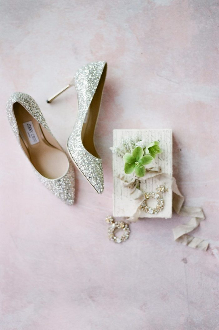 Sparkly silver high heels against a pink backdrop
