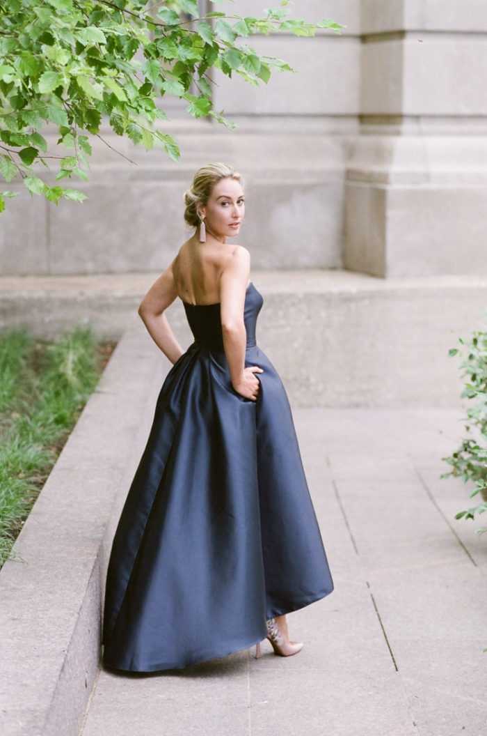 Woman looking over shoulder wearing a strapless navy blue evening dress in Chicago