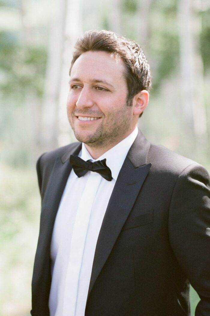 Groom in black tuxedo smiling