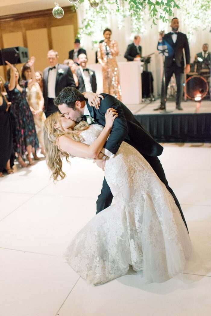 Wedding couple kissing after first dance on white dance floor