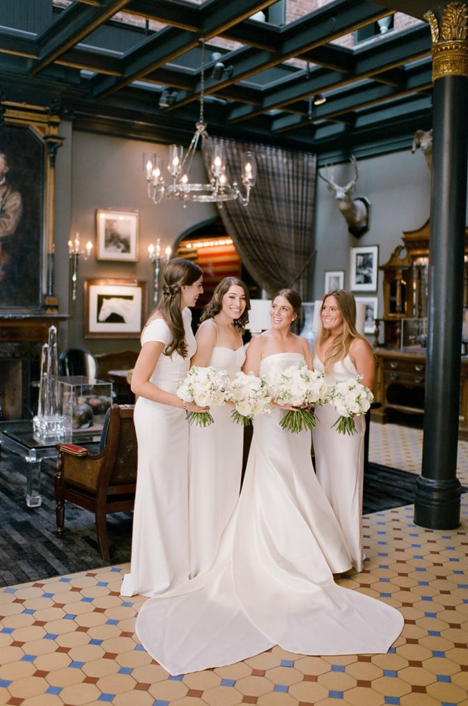 Bridesmaids posing together with large white flower bouquet