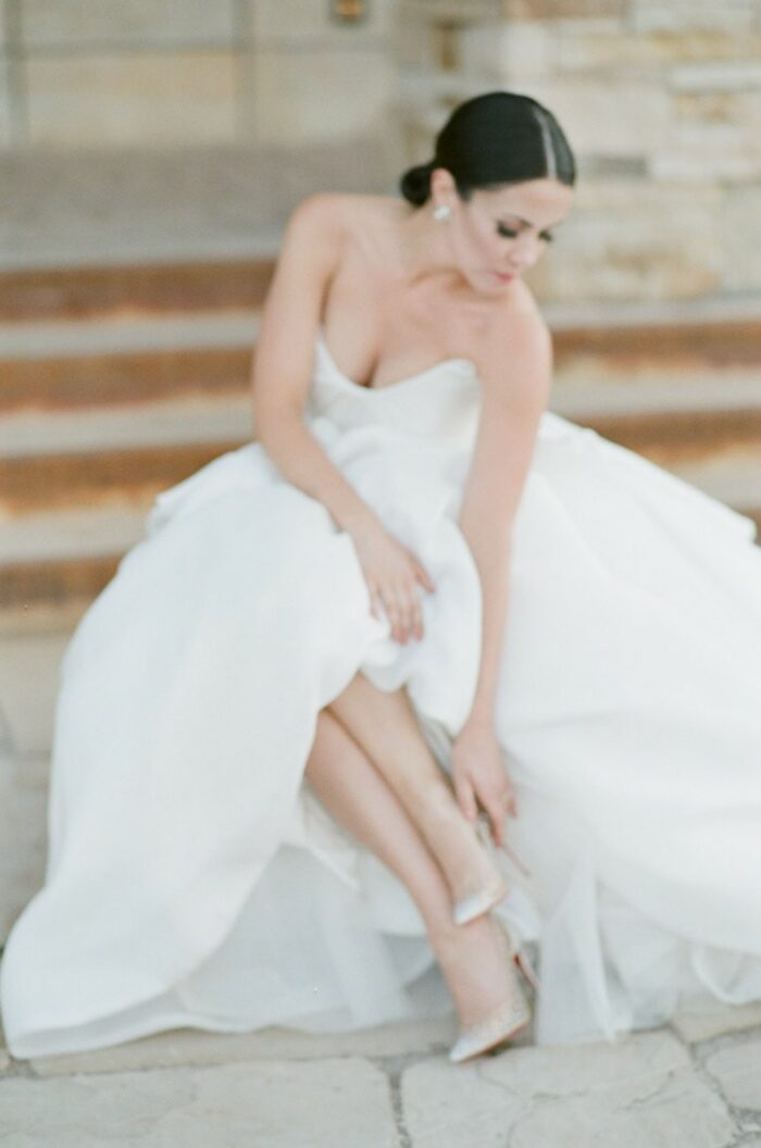 Bride in wedding gown checking heels