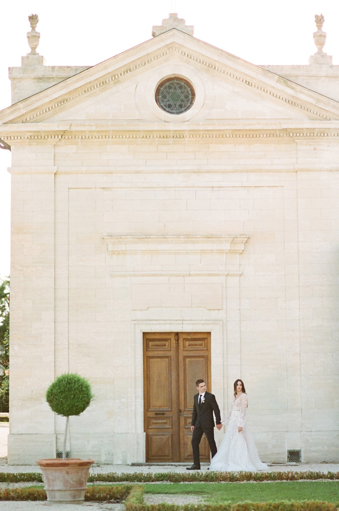 Couple in front of large white building with large door