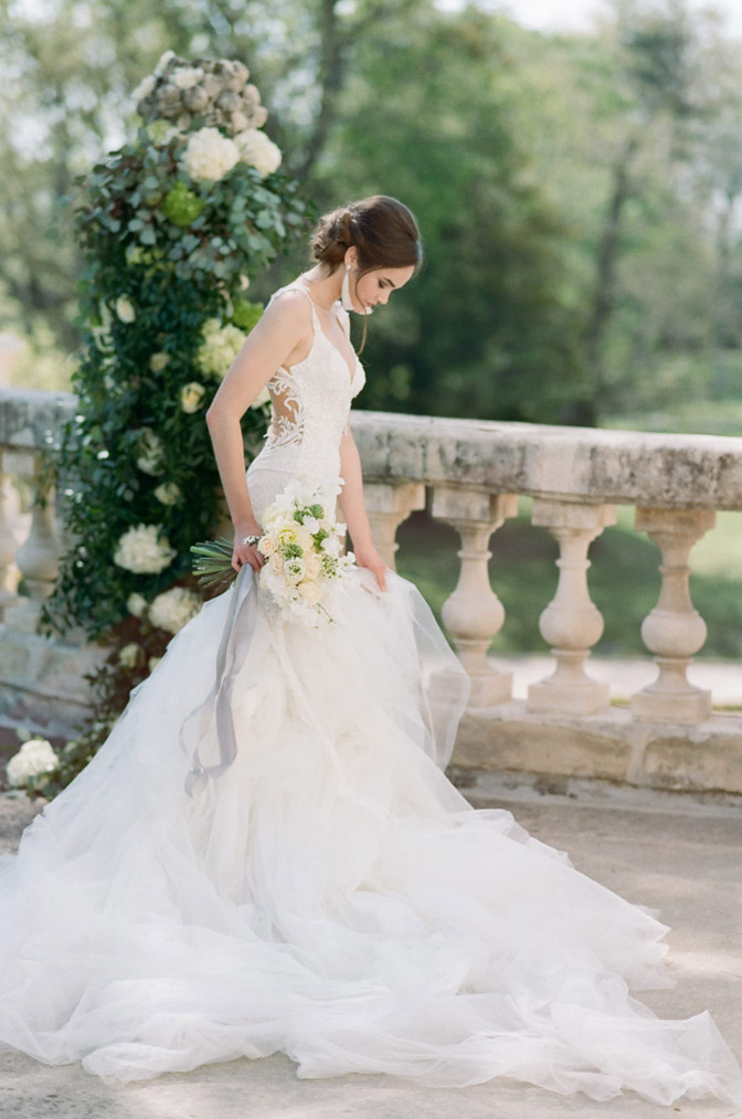 Bride in white lace gown holding bouquet