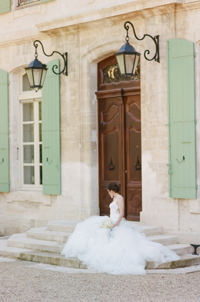 Bride sitting on entry steps to Chateau de Tourreau