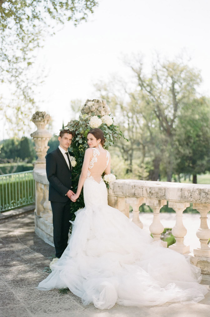 Bride & groom next to detailed stone railing