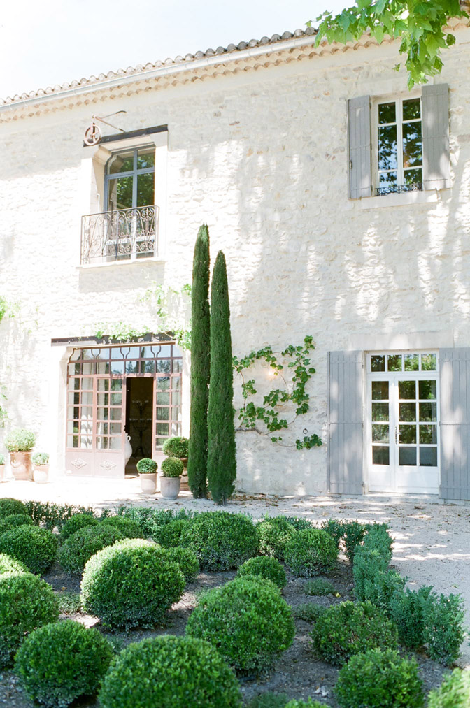 Green shrubbery and white stone wall of building