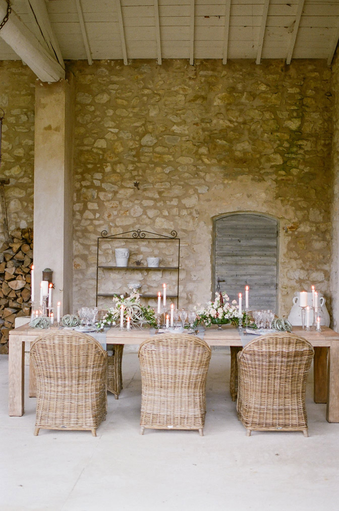 Wedding reception table setup with rustic stone wall background