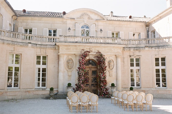 Grand entrance of Château Martinay in Provence accented by florals for a wedding ceremony