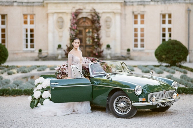 Bride stepping into a classic convertible near her destination wedding ceremony at Château Martinay