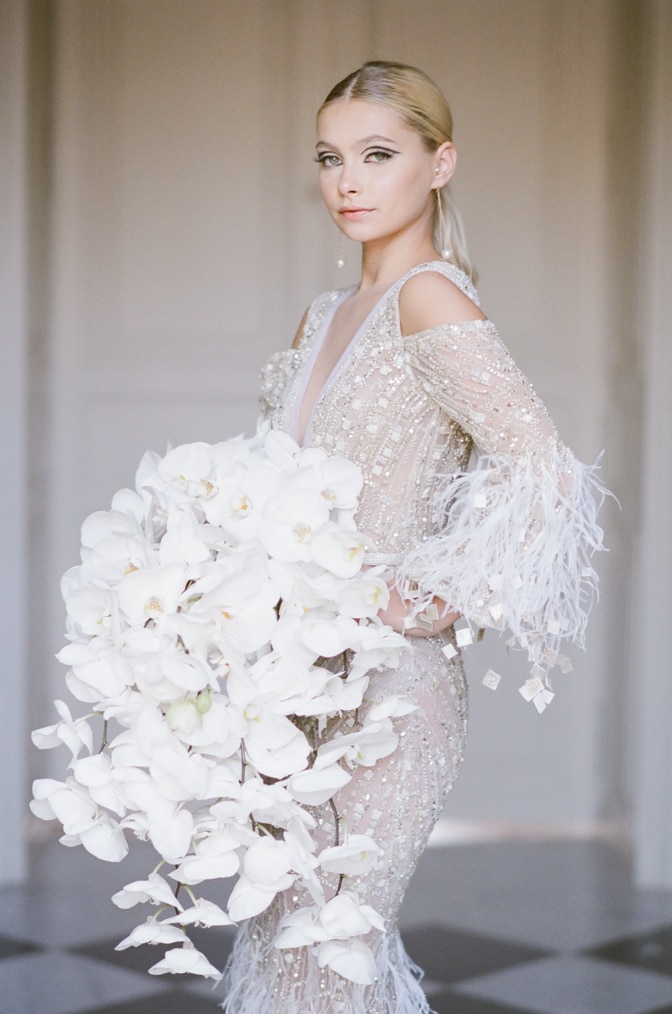 Bride wearing Ziad Nakad gown and holding an orchid bouquet