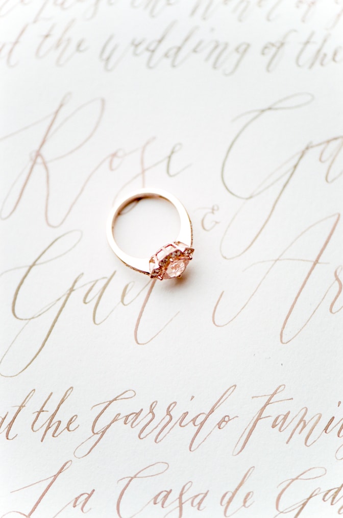 Closeup of a luxury designer engagement ring by Brian Gavin placed on an invitation suite