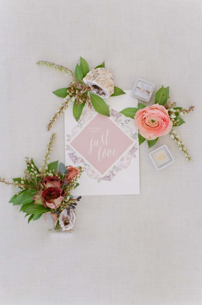 Closeup of luxury wedding invitation shown in blush and white