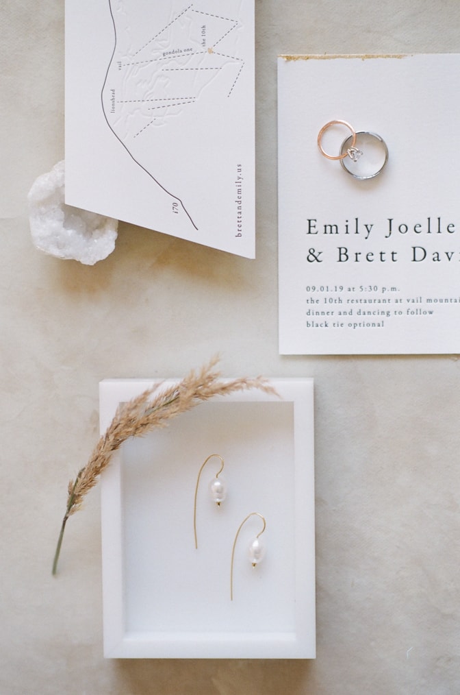 Closeup of modern luxury letterpress wedding invitation and earrings