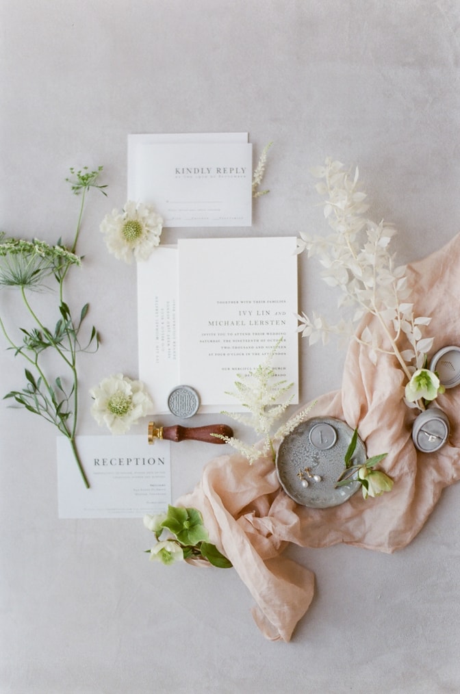 Modern luxury letterpress wedding invitation surrounded by florals