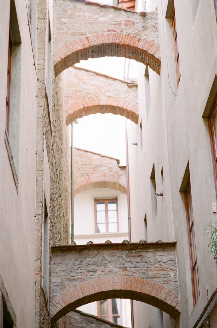 Arches connecting buildings in a small street of Florence in Italy