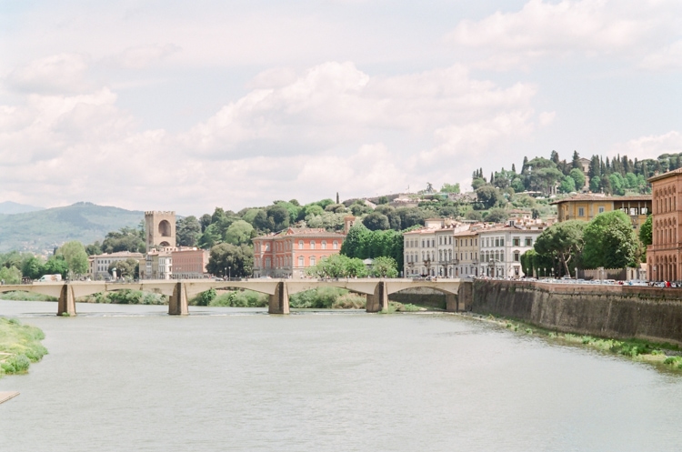 Beautiful bridge on the river Arno in Florence and soft buildings and greenery behind it