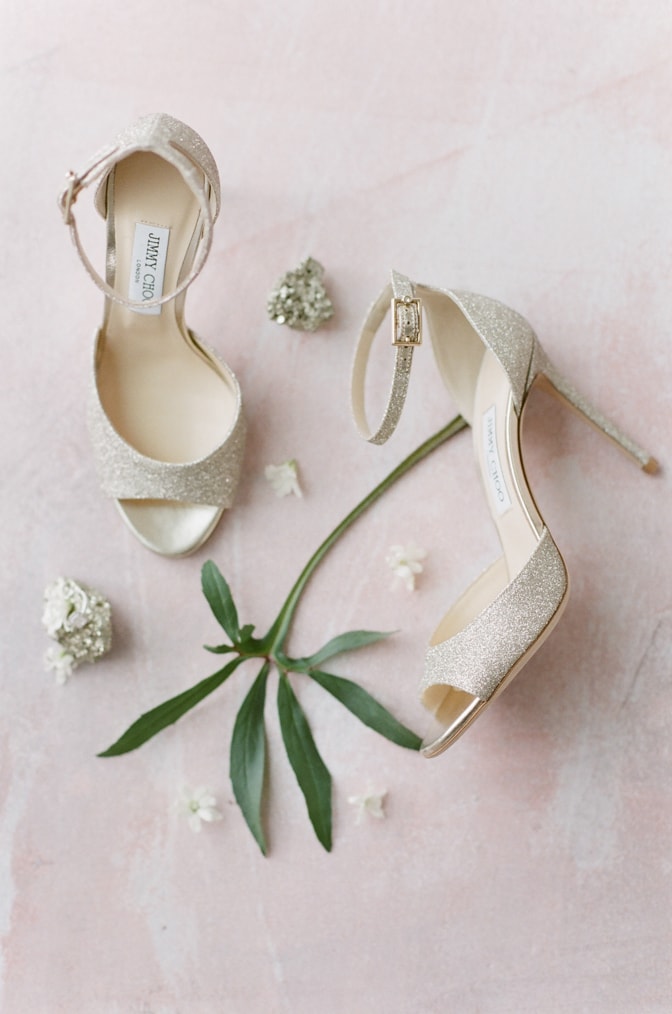 Luxury gold wedding Jimmy Choo shoes surrounded by flowers