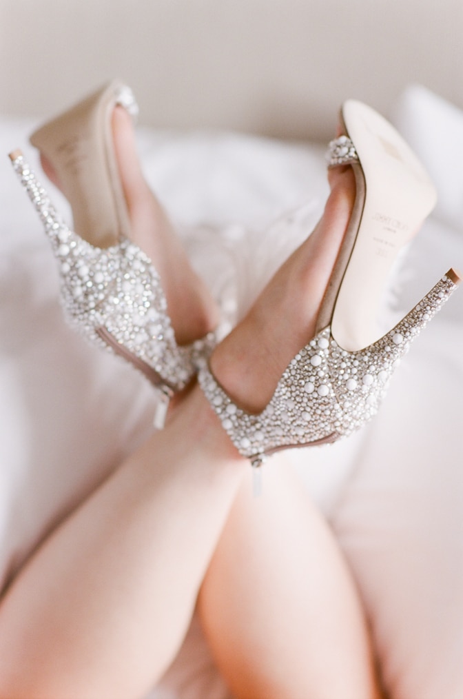 Bride wearing her luxurious Jimmy Choo shoes adorned with pearls