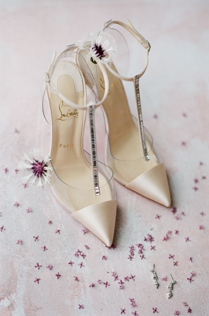 Louboutin blush glamour shoes surrounded by flowers