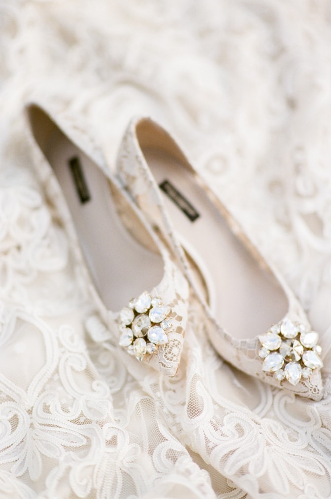 White lace Manolo Blahnik shoes with a brooch