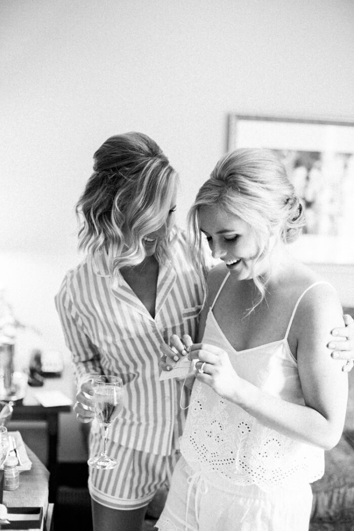 Bride embracing her maid of honor during getting ready session