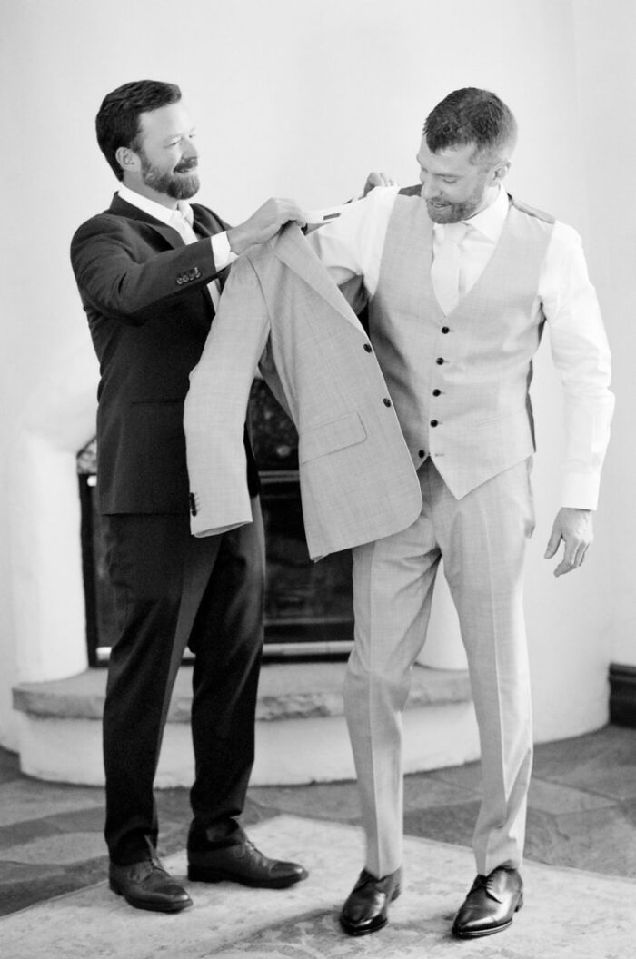 Best man dressing the groom at Colorado wedding