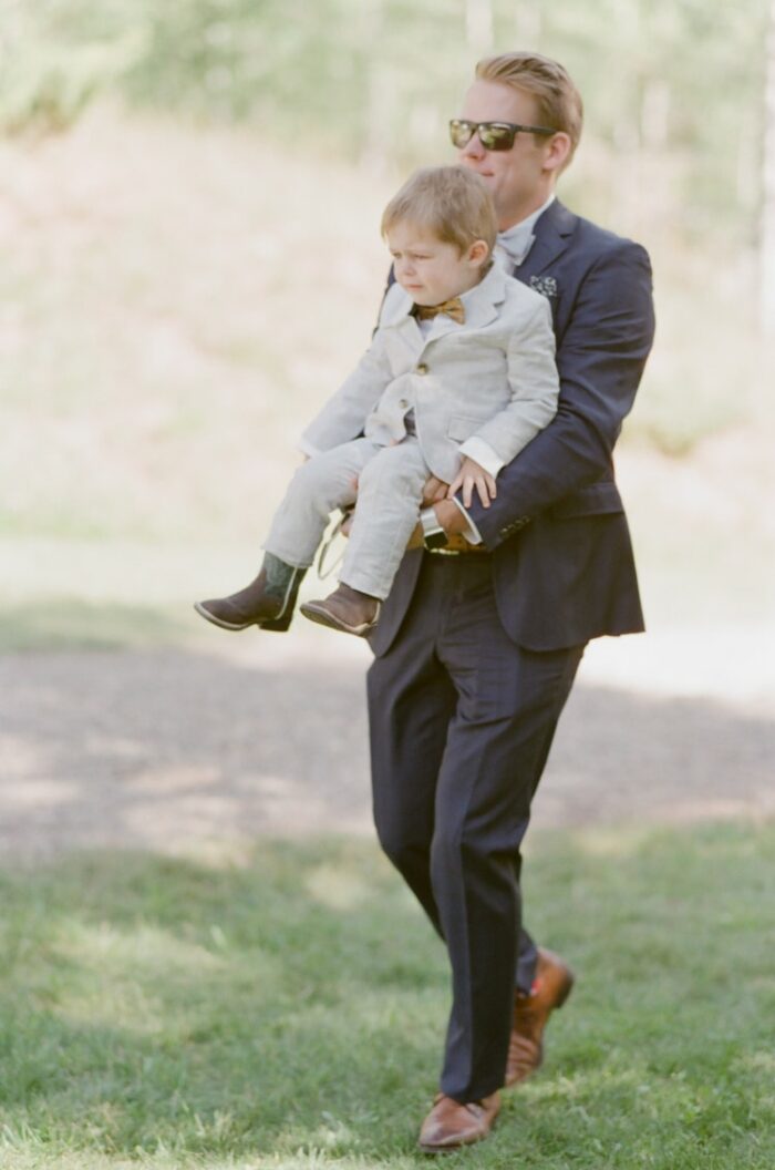 Wedding guest carrying ring bearer at Eaton Ranch