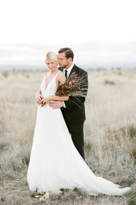 Bride and groom embracing each other during their summer garden wedding in Marfa