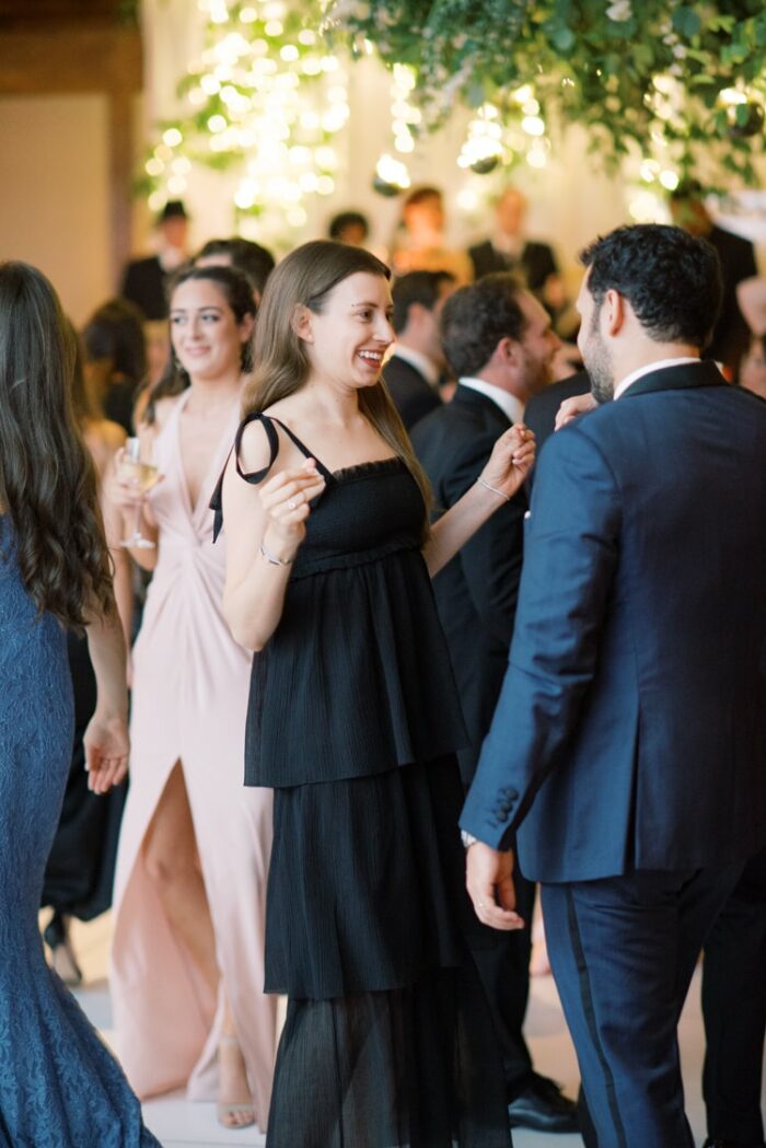 Woman in black dress dancing at wedding reception