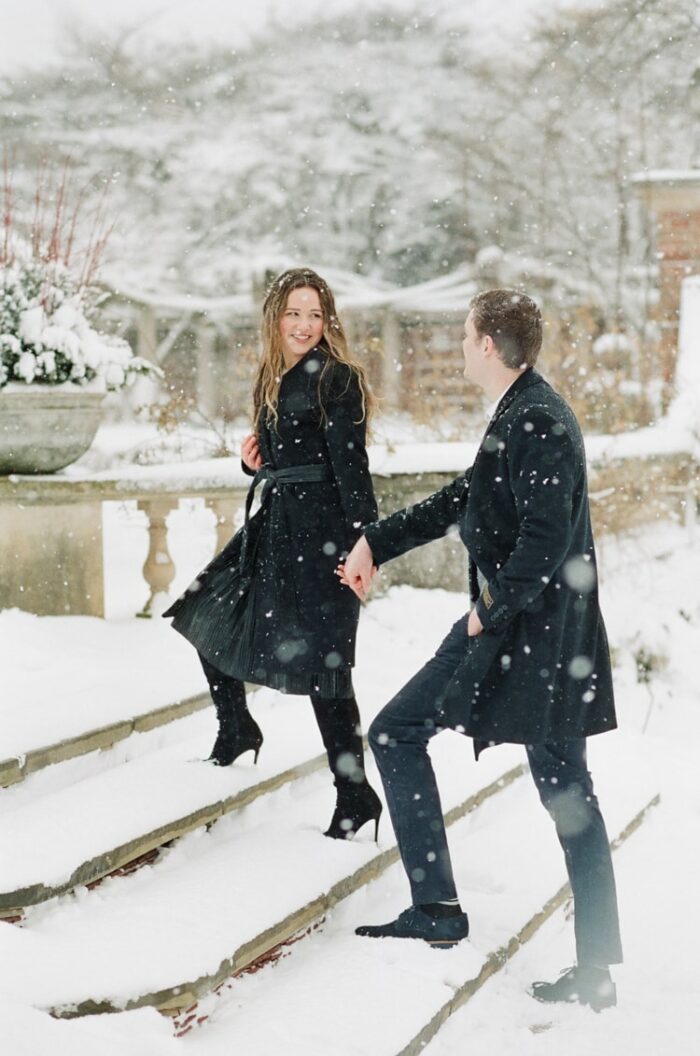 Engaged couple walking up the stairs at English Walled Garden