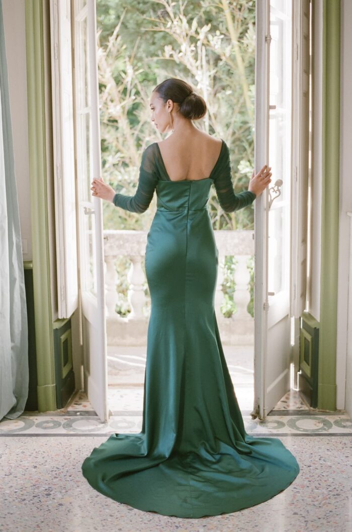 Bride standing in front of French windows holding them