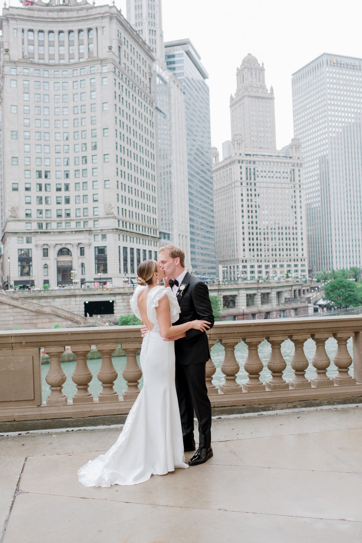 Bride and groom kissing each other in front of city skyline
