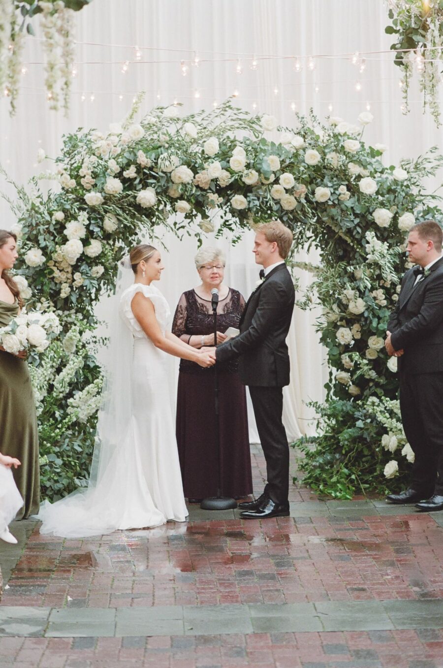 Bride and groom standing in front of floral arch during Chicago ceremony