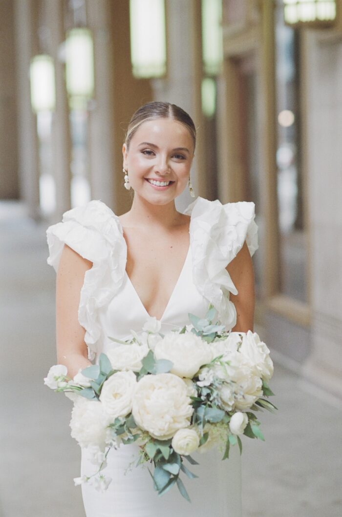Bride in Rime Arodaky dress holding her wedding bouquet