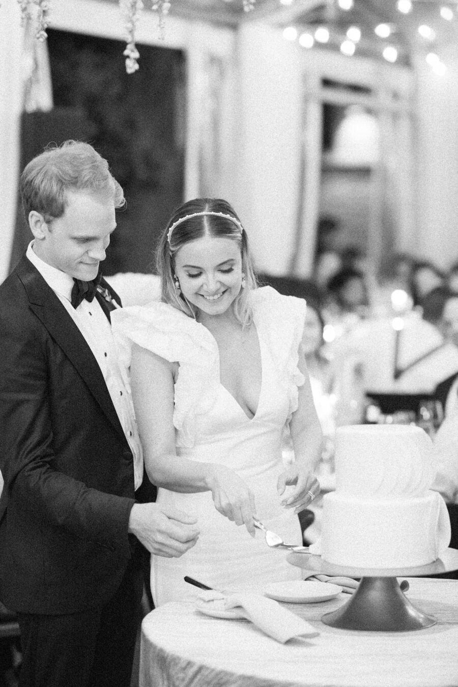 Bride and groom cutting wedding cake during their reception