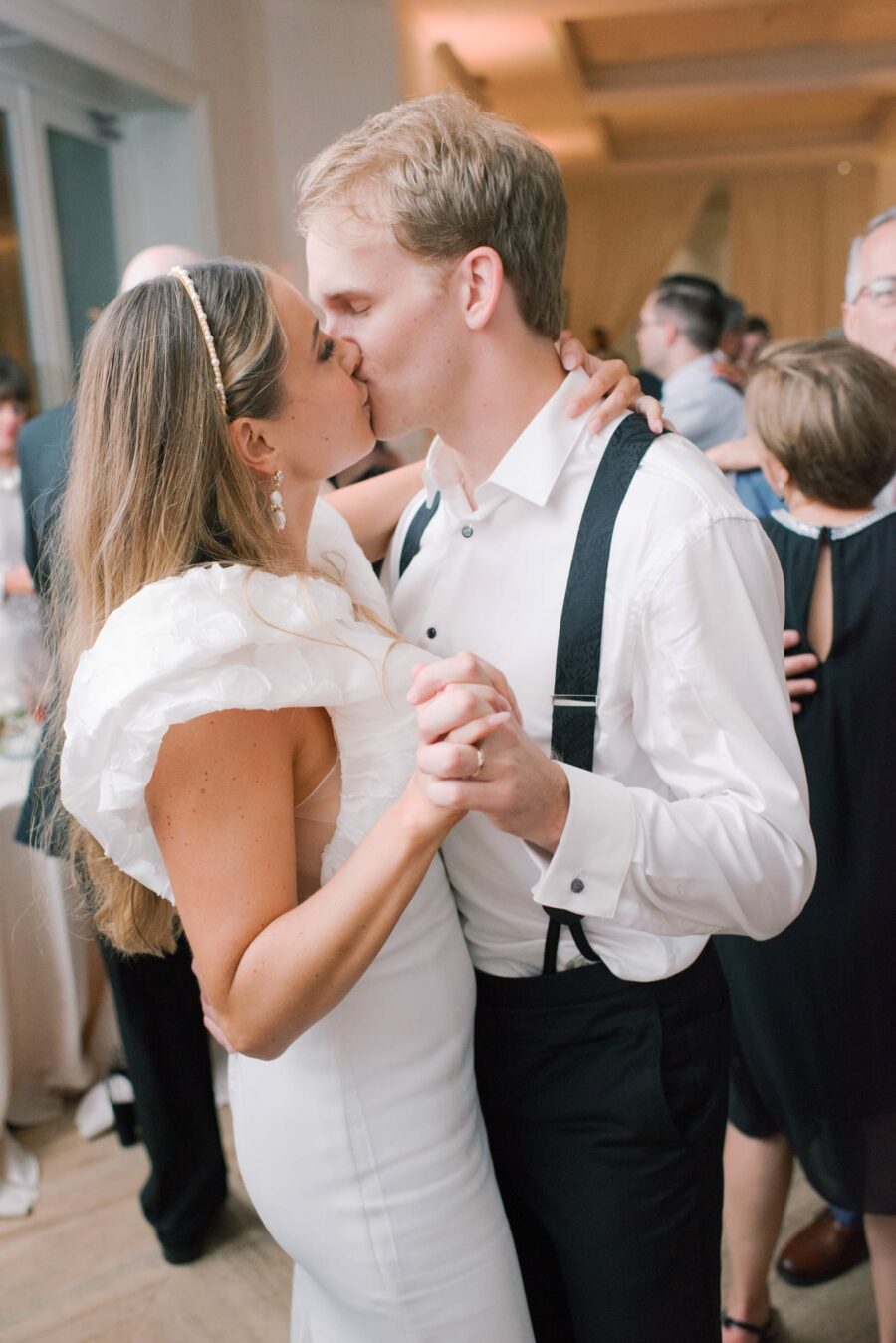 Bride and groom kissing each other during wedding reception while dancing
