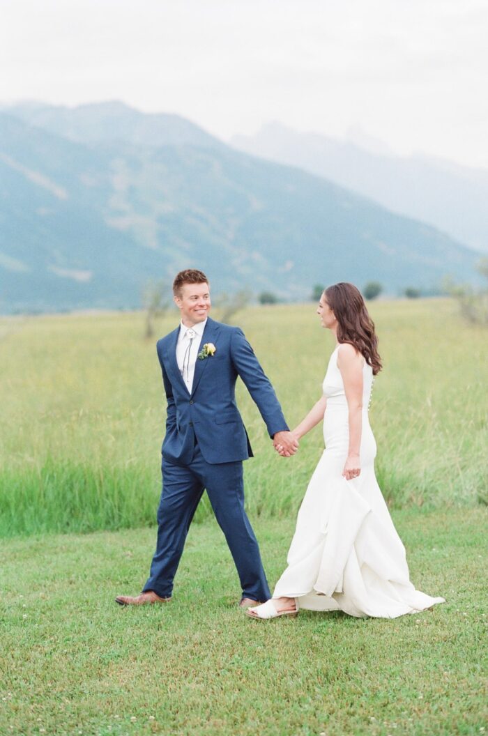 Bride and groom walking in front of Grand Tetons