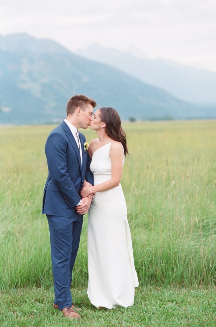 Bride and groom kissing in front of Grand Tetons