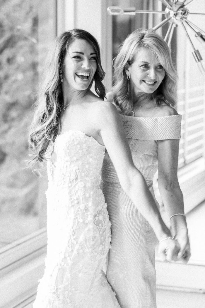 Bride and mother of bride embracing each other and smiling