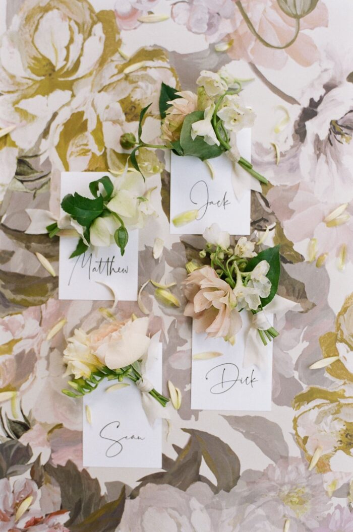 Boutonnieres displayed on floral backdrop for St Louis wedding