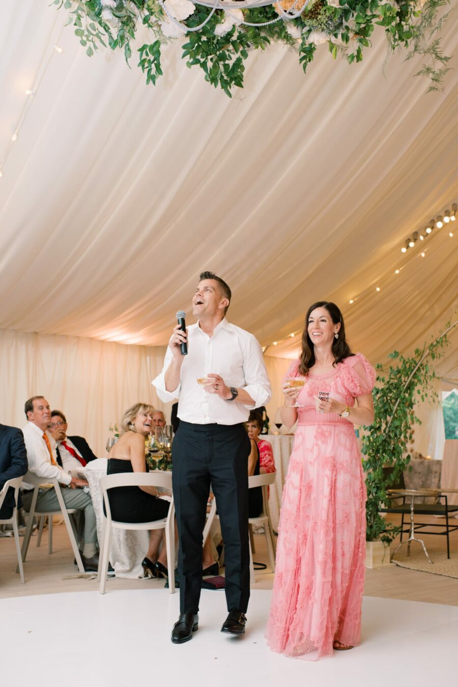 Bride's parents giving speech at tented reception