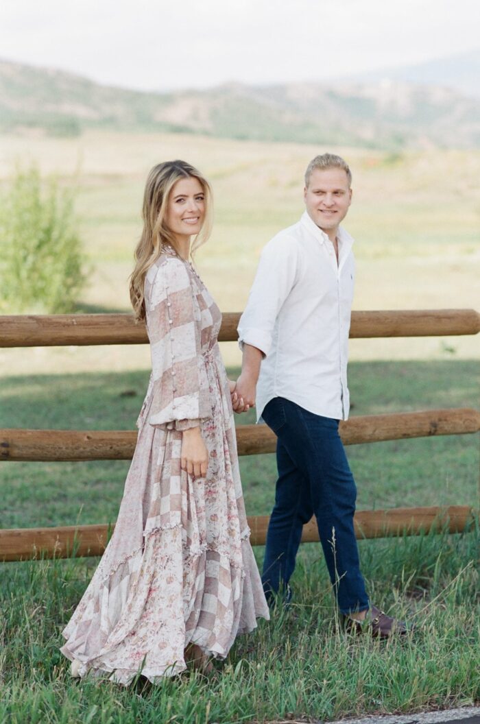 Bride and Groom walking hand in hand in front of Aspen mountains